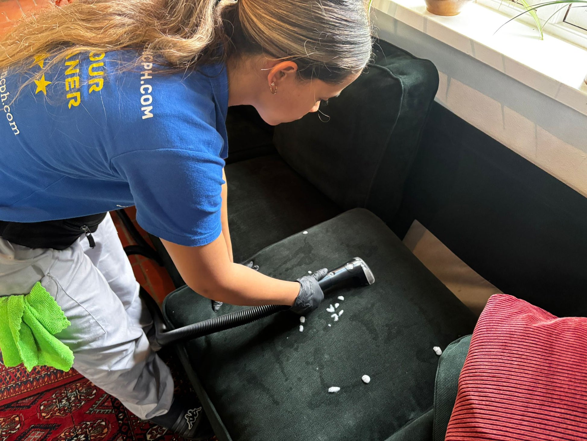 Professional sofa deep cleaning service in Copenhagen with a technician using a vacuum.