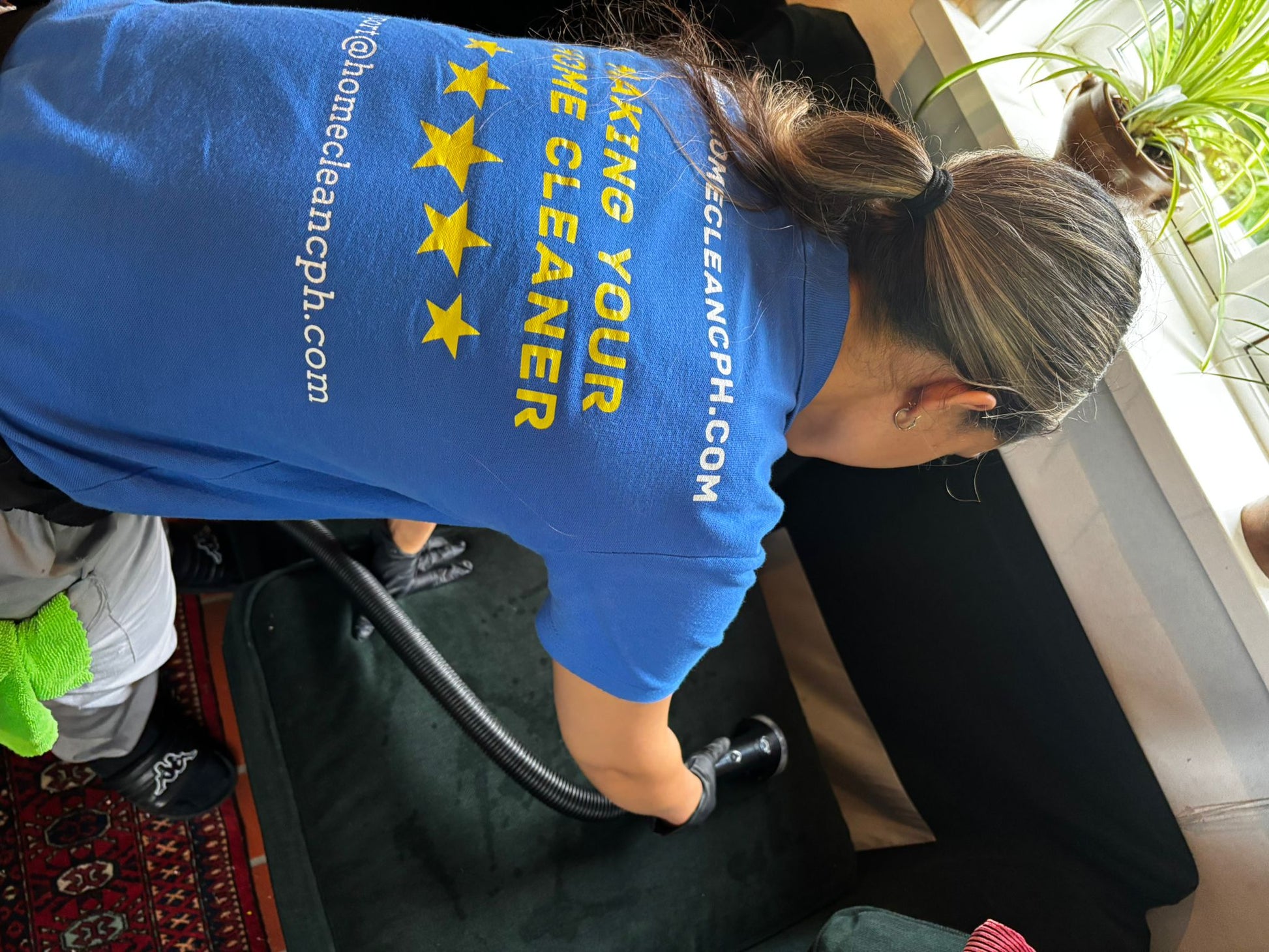 Professional cleaner deep cleaning a sofa in Copenhagen for Home Clean CPH.