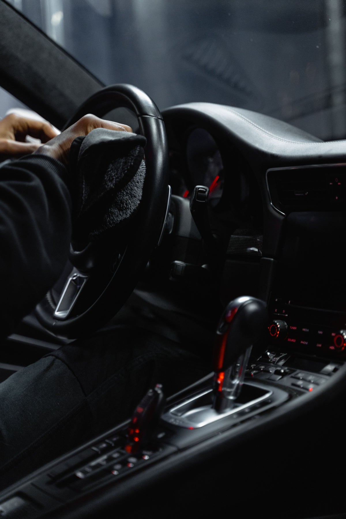 Wiping the steering wheel with a cloth during car interior cleaning